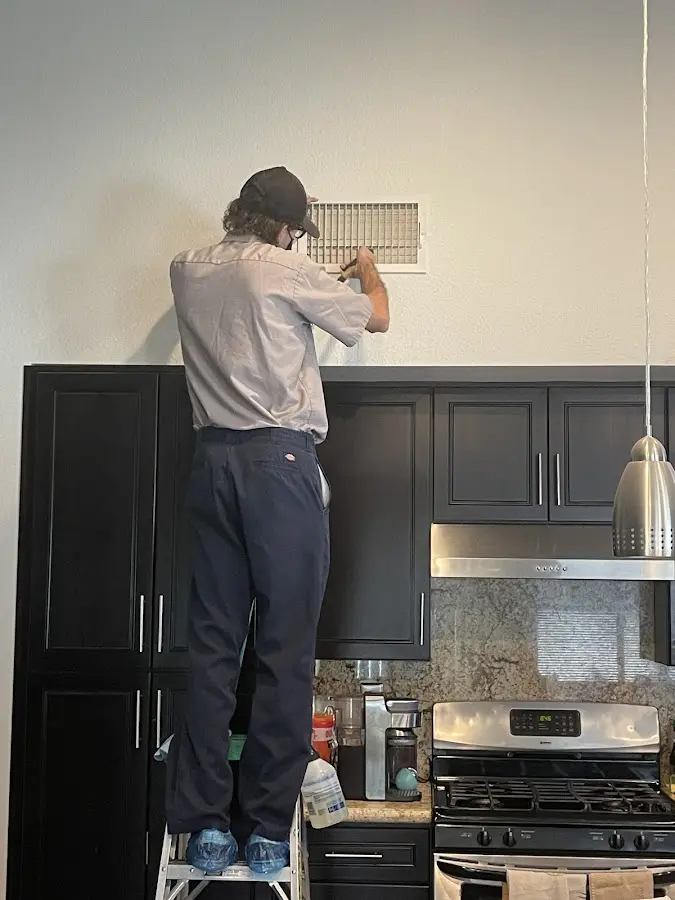 Technician inspecting an air vent during HVAC service in Tredyffrin